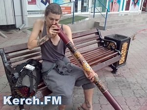 Уличный музыкант в Керчи играет на инструменте аборигенов